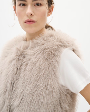 Faux fur vest features a regular fit, sleeveless cut, and round neckline. Perfect for layering, this piece offers a cozy feel and stylish silhouette for versatile outfits.