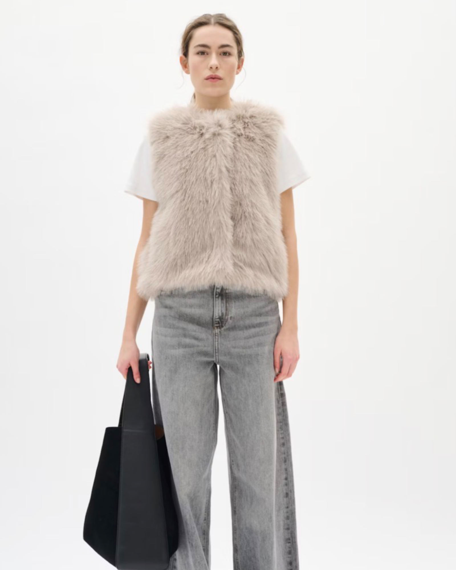 Faux fur vest features a regular fit, sleeveless cut, and round neckline. Perfect for layering, this piece offers a cozy feel and stylish silhouette for versatile outfits.