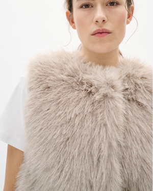 Faux fur vest features a regular fit, sleeveless cut, and round neckline. Perfect for layering, this piece offers a cozy feel and stylish silhouette for versatile outfits.
